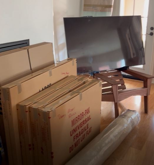 Stack of boxes securely taped and labeled 'fragile' to indicate they contain delicate items such as mirrors and glass whiteboards, prepared for safe transport.